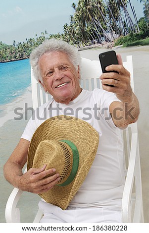 Mature man in vacation taking a picture of himself with cell phone at the tropical beach