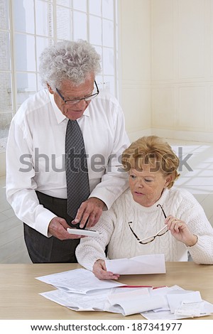Senior couple look surprised  while reading letters, and bills
