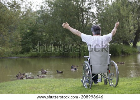 handicapped man on a wheelchair alone in a park