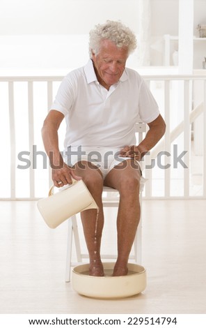 Senior man having a foot bath
