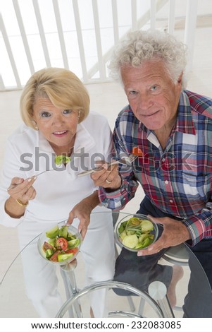 senior couple at home eating together a tomato salad