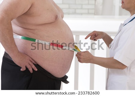 Doctor measuring waist to an overweight senior man