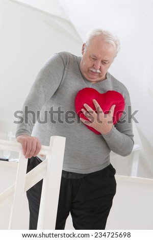 Senior man holding an heart symbol of heart attack