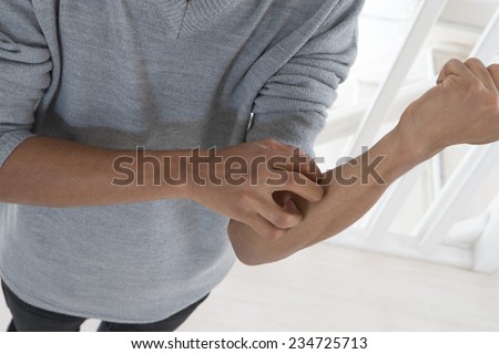 young mulatto man with itching arm