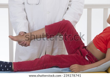 Doctor examining boy leg because of knee problem symptoms