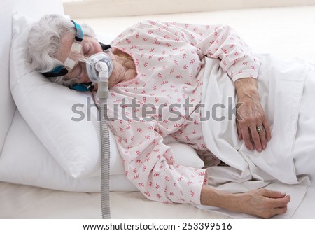 elderly  woman is sleeping with a CPAP machine (For people with sleep apnea.)