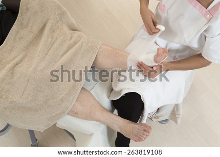 Nurse  doing a bandage for patient. First aid
