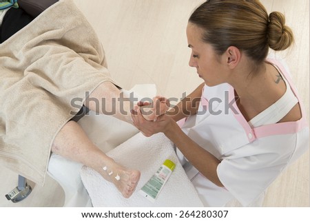 Nurse or care giver massaging foot   of an elderly woman