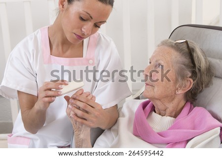 Older senior woman receiving home beauty treatment hand\'s care