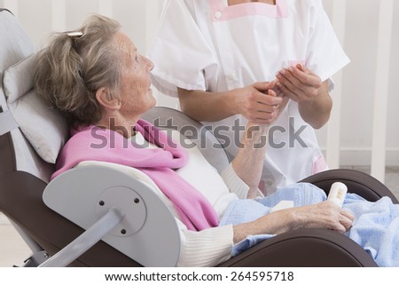 Older senior woman receiving home beauty treatment hand\'s care