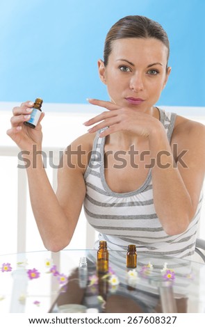 beauty and cosmetics concept - beautiful woman smelling perfume on her hand