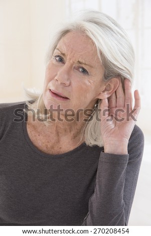 Elderly woman with hardness of hearing listening