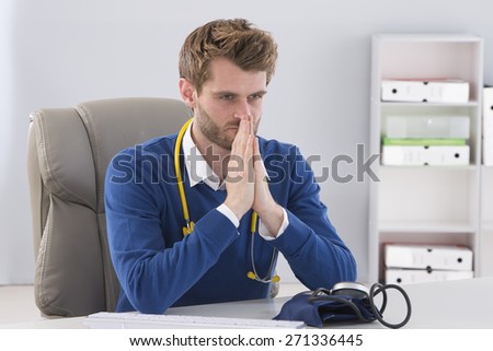 depressed young  doctor touching at his office