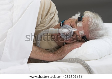 SLEEP APNEA SYNDROME -Senior man using CPAP machine