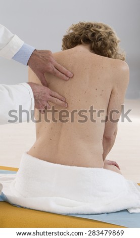 Chiropractor massage to female patient spine and back