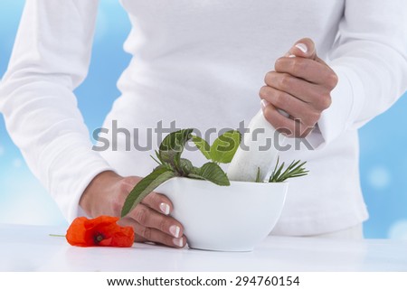 Young woman holding mortar with herbs