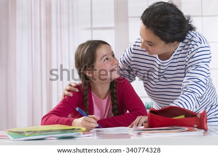 Mom helping her daughter do homework