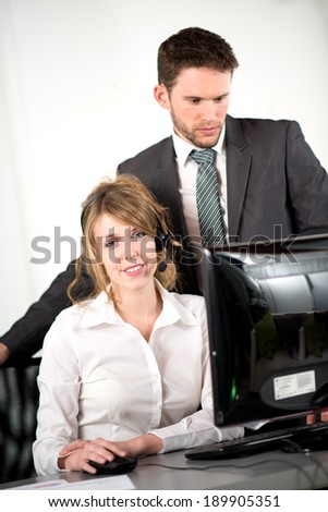 portrait of two business people working together in office with computer