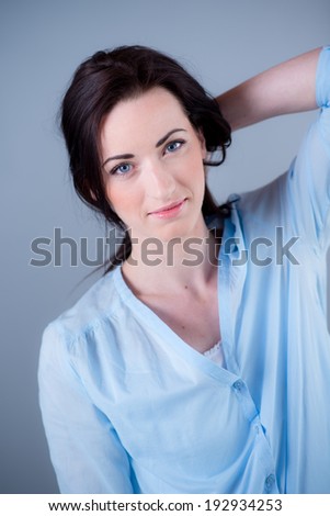 Isolated studio portrait of cheerful young woman on blue background