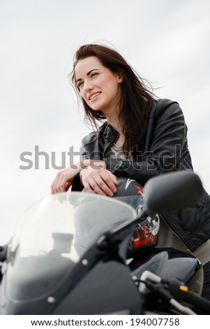 cheerful and beautiful young woman riding motorbike