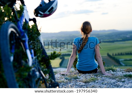 healthy and cheerful young woman riding mountain bike outdoor in the country