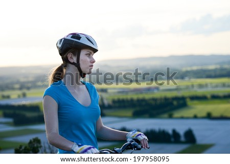 healthy cheerful young woman riding mountain bicycle outdoor in beautiful countryside landscape