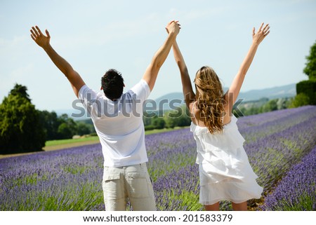 romantic young couple, man and woman during summer holiday having fun in lavender field in provence south France