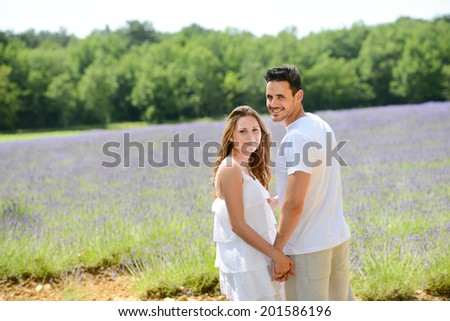 romantic young couple man woman in summer holiday in lavender field in provence south France