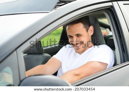 happy handsome young man driving his new car in countryside summer vacation