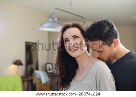 handsome young man kissing beautiful young girlfriend in her neck