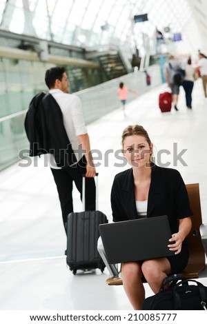 business woman sitting in public station and working with a computer in wifi area