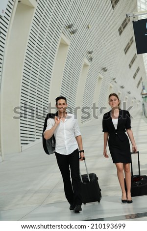 young business travelers commuters man and woman walking in a public station