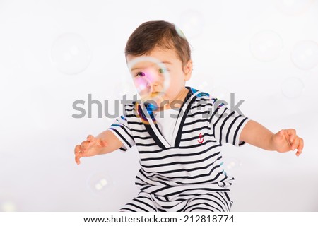 isolated studio portrait on white background of lovely toddler baby boy playing and laughing