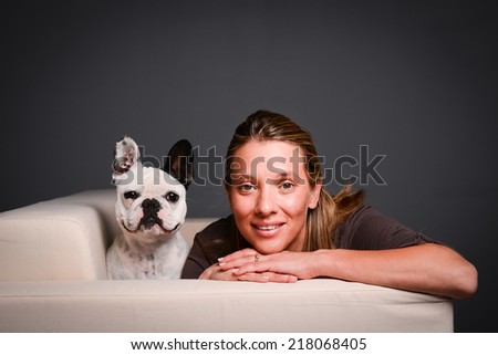 isolated studio shot of beautiful young woman with her pet little dog french bulldog