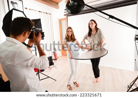 handsome young photographer taking pictures of a beautiful girl  fashion model