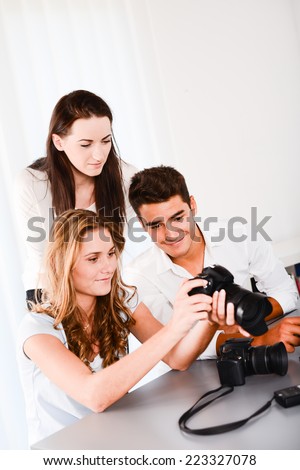 young student with teacher during photography editing course with a computer and cameras