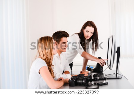 young student with teacher during photography editing course with a computer and cameras