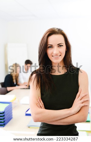 Beautiful young woman executive manager in a meeting room isolated with business team in background