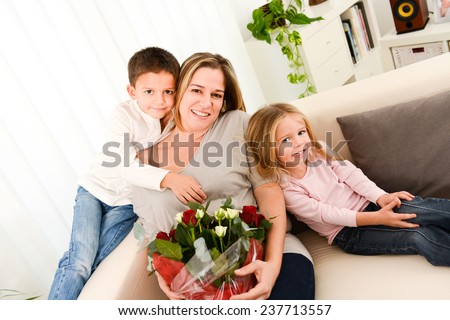 young happy children offering flowers to their mum during mother\'s day