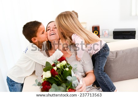 young happy children offering flowers to their mum during mother\'s day