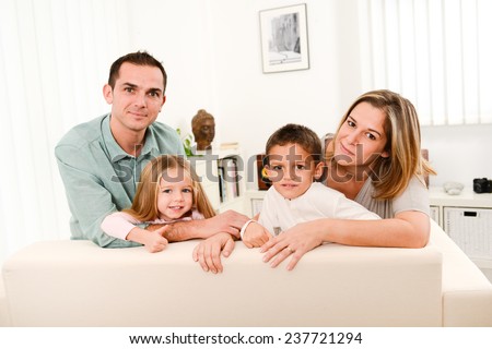 happy cheerful family with young kids playing together in the sofa at home
