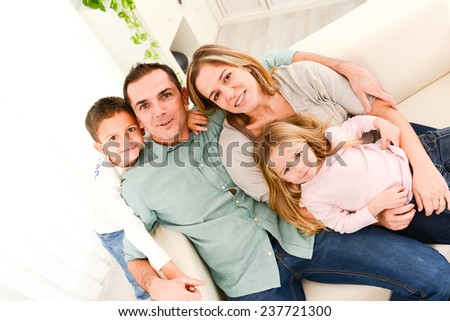 happy cheerful family with young kids playing together in the sofa at home