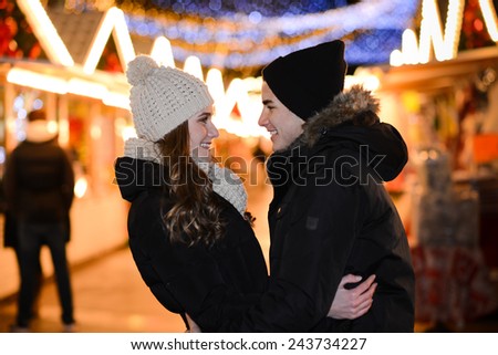 cheerful happy young couple having fun downtown at night during winter