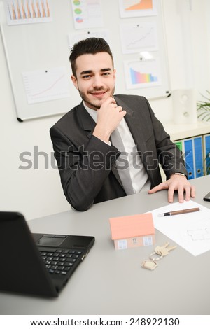 real estate agent salesman at desk in office