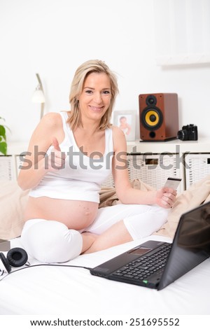 beautiful forty years old pregnant woman web surfing and shopping on internet