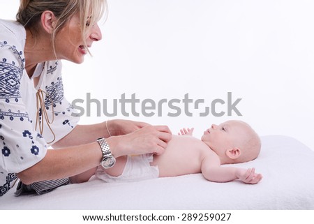 mature blonde woman playing and taking care of her lovely new born baby boy