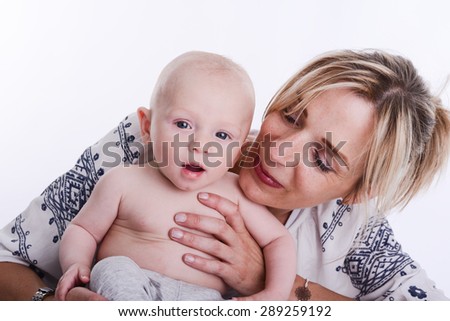 mature blonde woman holding and taking care of her lovely new born baby boy