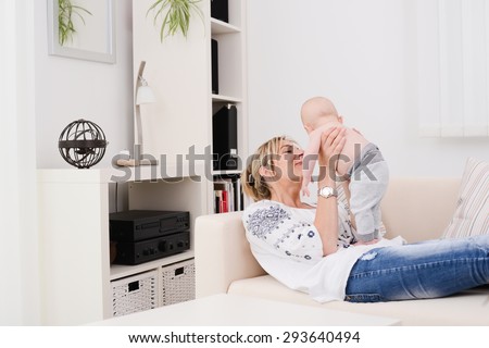 young woman at home playing and taking care of lovely new born baby boy