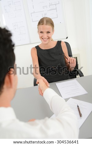 beautiful young business woman handshake with customer in office after signing agreement sales contract