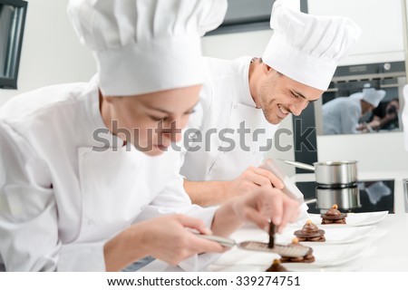 pastry cook professional team man and woman in restaurant kitchen preparing a chocolate dessert